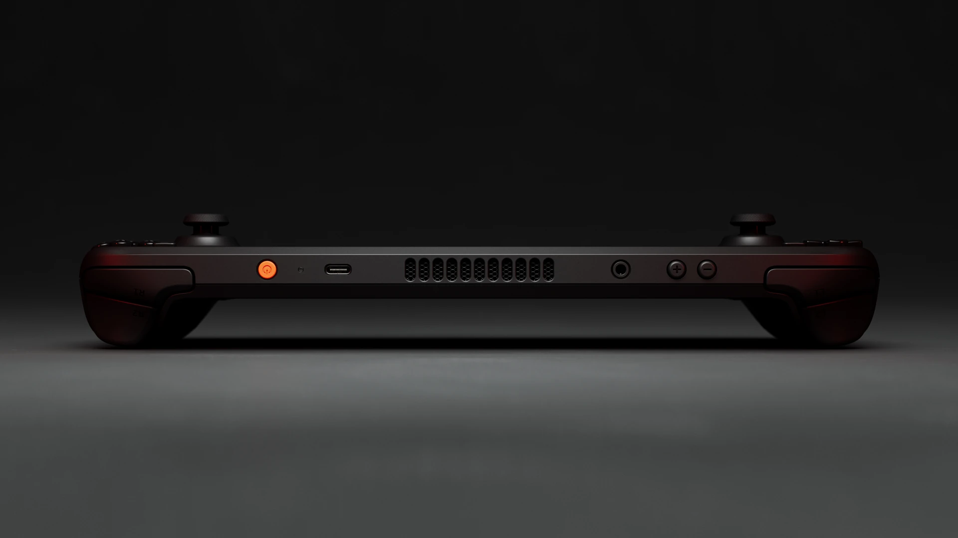 Valve's render of the Steam Deck OLED's top edge, showing the orange power button, USB-C port, air vent, headphone jack and volume buttons between the two grips.