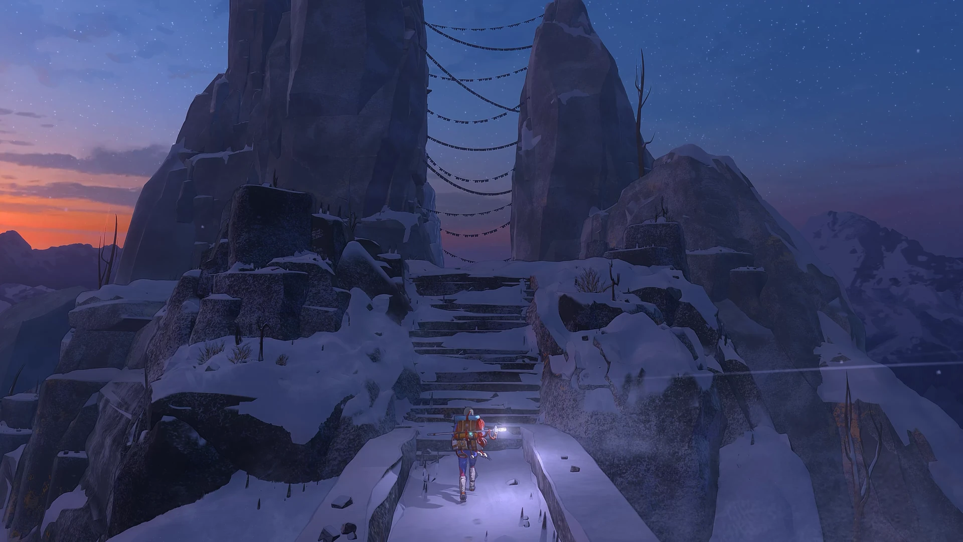 Official Cairn screenshot of Aava with a headlamp at the foot of snowy stone steps that climb between two rock pillars strung with prayer flags, under a dusk sky.